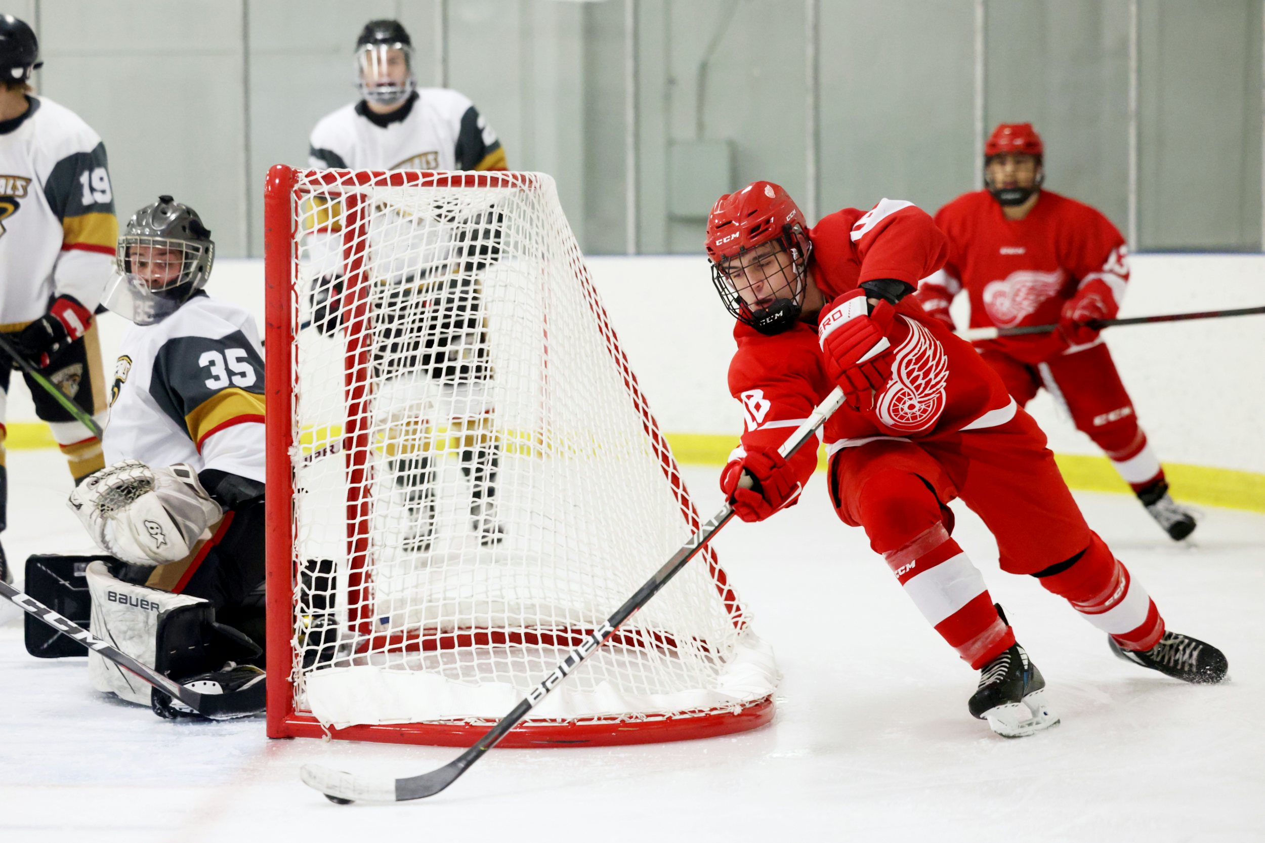 EDMONTON, AB - December 5: North Edmonton Red Wings forward Dylan Gagne #18 attacks the net as Spruce Grove Regals goaltender Easton Cutler #35 looks on during Capital Junior Hockey League play at the Londonderry Recreational Centre in Edmonton, AB on December 5th, 2023. (Photo by James Maclennan)