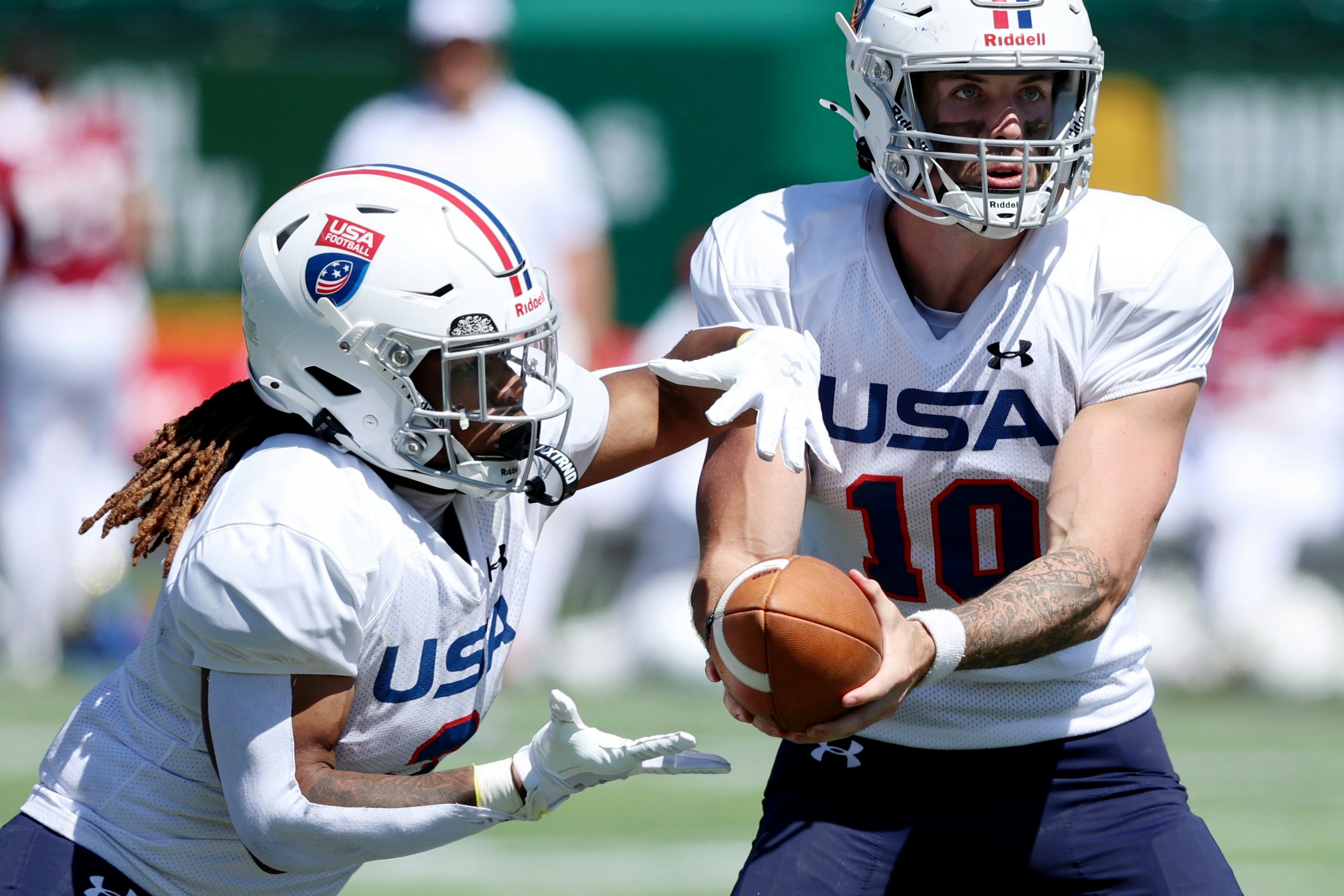 EDMONTON, AB - June 22: Team USA quarterback Alaim Appler hands off to Keon Kenner during IFAF U20 World Junior Football Championiship gameplay at Commonwealth Stadium in Edmonton, AB, Canada on June 22nd, 2024. (Photo by James Maclennan)